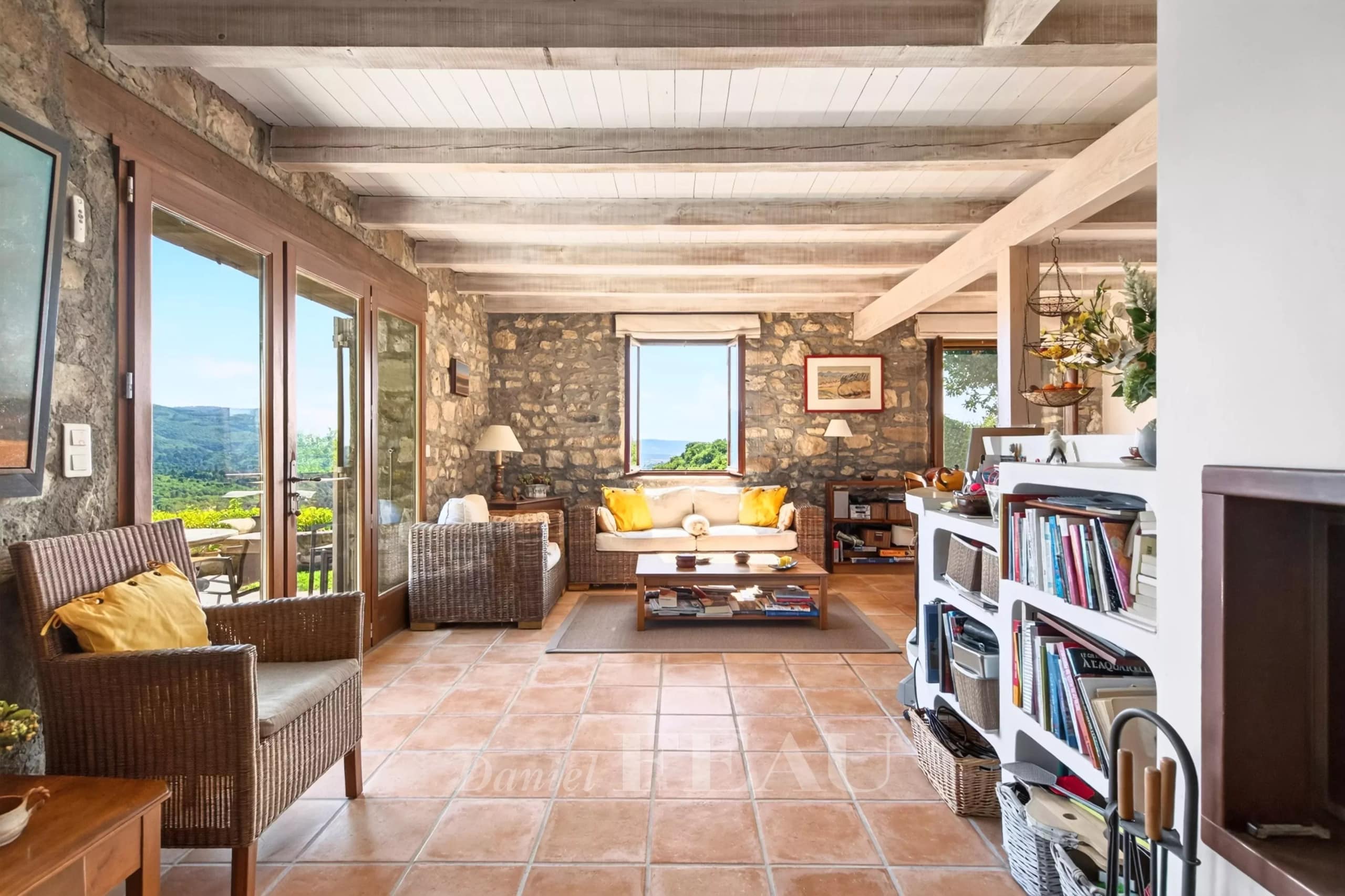 Interior of a stone house with a bright living room and a view of nature.