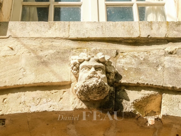Mas en pierre avec un visage sculpté sur la façade à Boulbon.