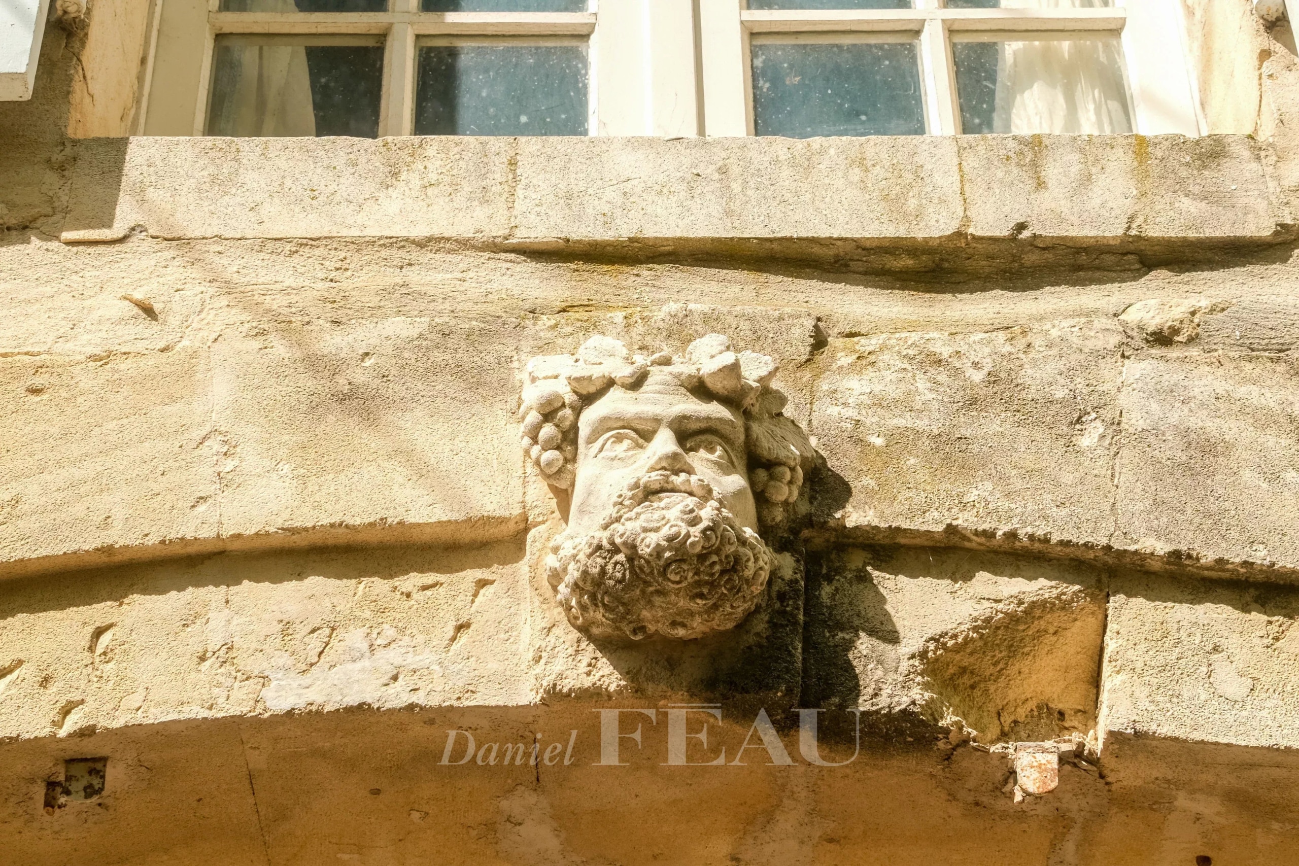 Mas en pierre avec un visage sculpté sur la façade à Boulbon.