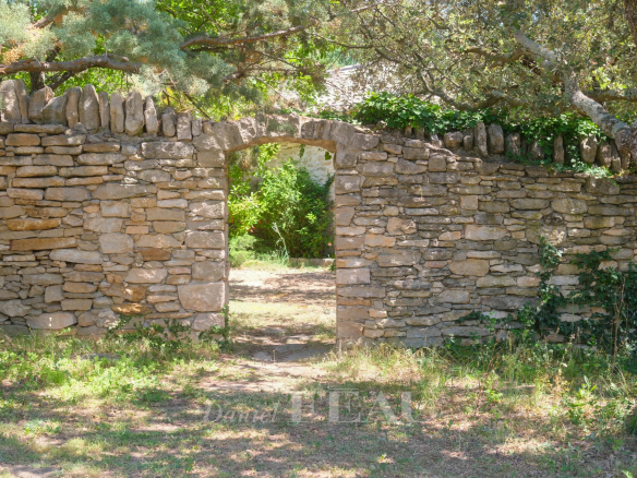 Portail en pierre dans un parc verdoyant à Ménerbes