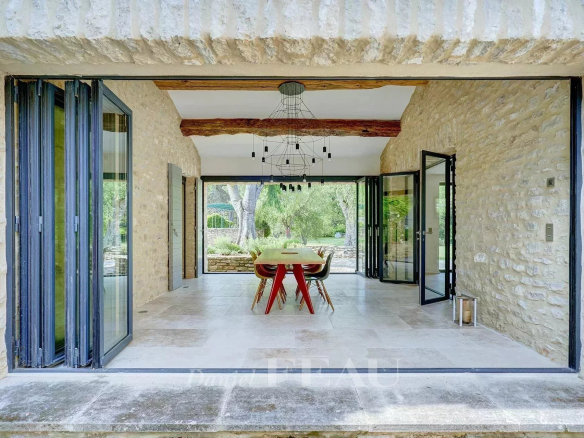 Intérieur d'un mas du XVIIIe siècle rénové, avec vue sur un jardin paisible.