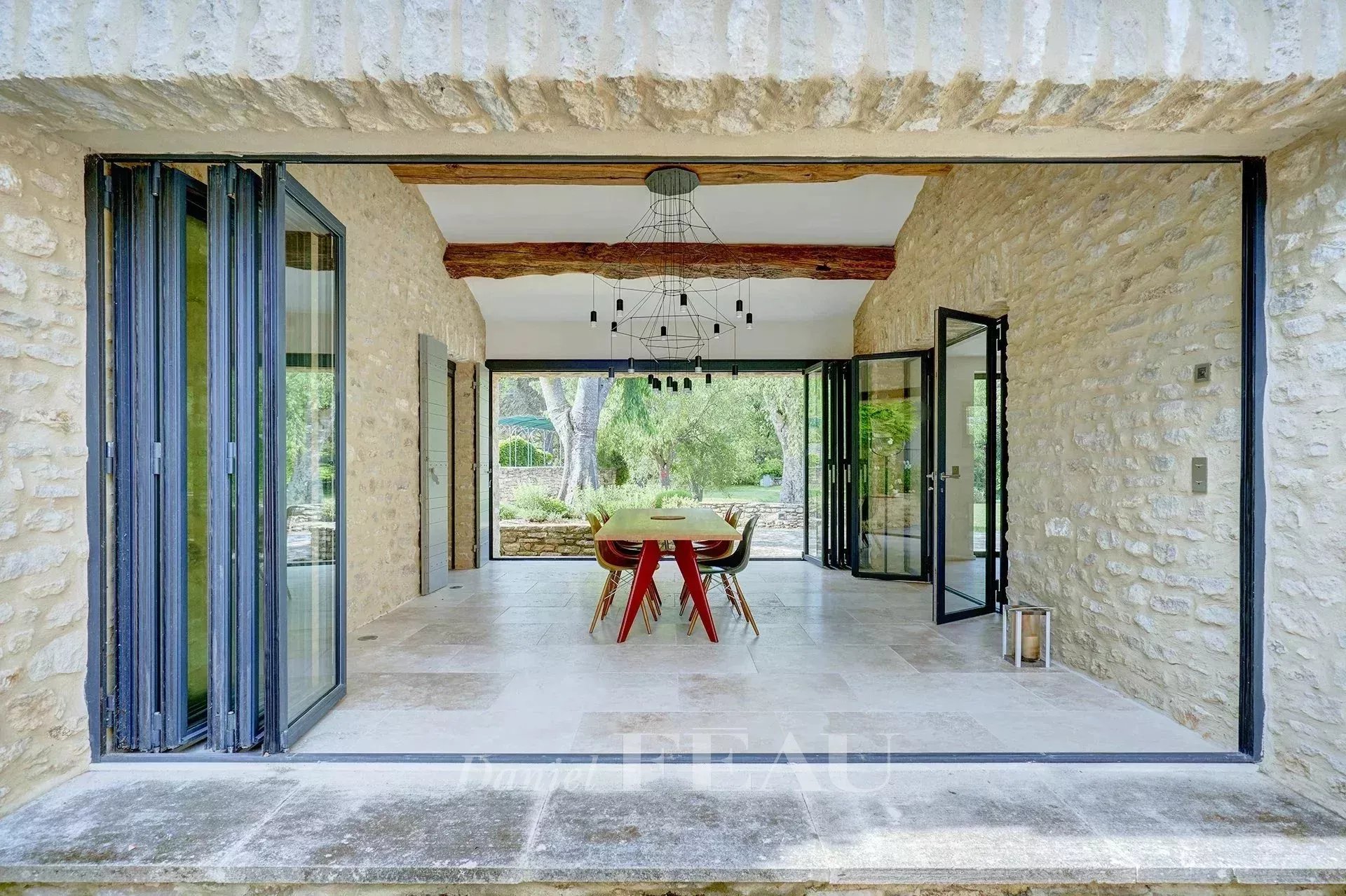 Intérieur d'un mas du XVIIIe siècle rénové, avec vue sur un jardin paisible.