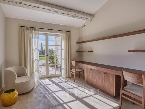 Interior of a renovated stone house with an office and a view of the garden.