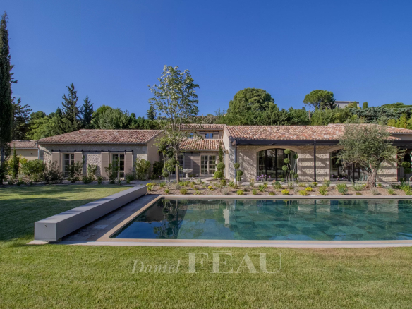 Renovated stone house with swimming pool in Maussane-les-Alpilles, surrounded by greenery.