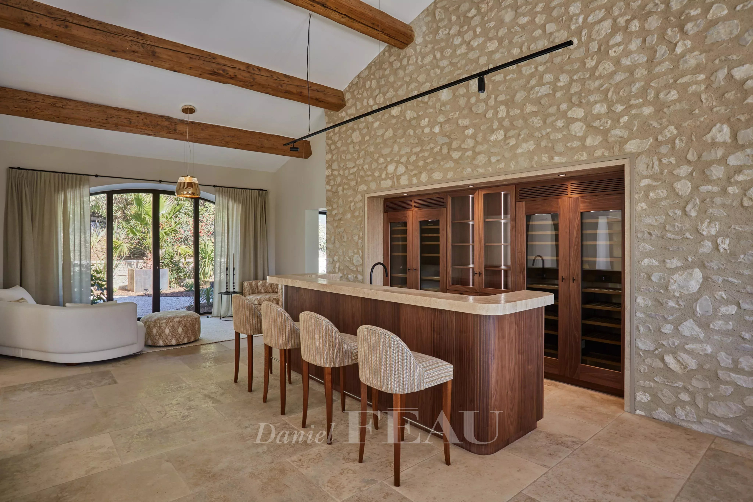 Interior of a renovated stone house with a bar and exposed beams.