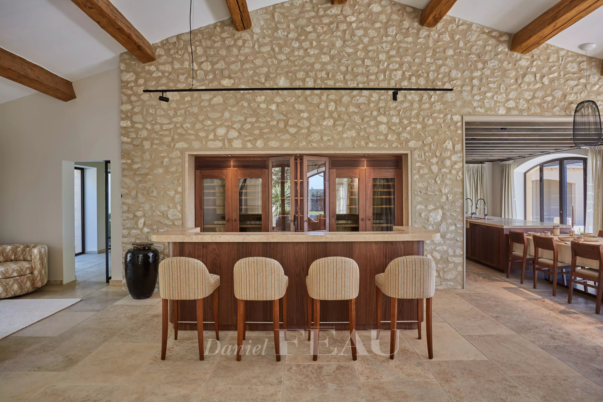 Interior of a renovated stone house with a bar and bright living space in Maussane-les-Alpilles.
