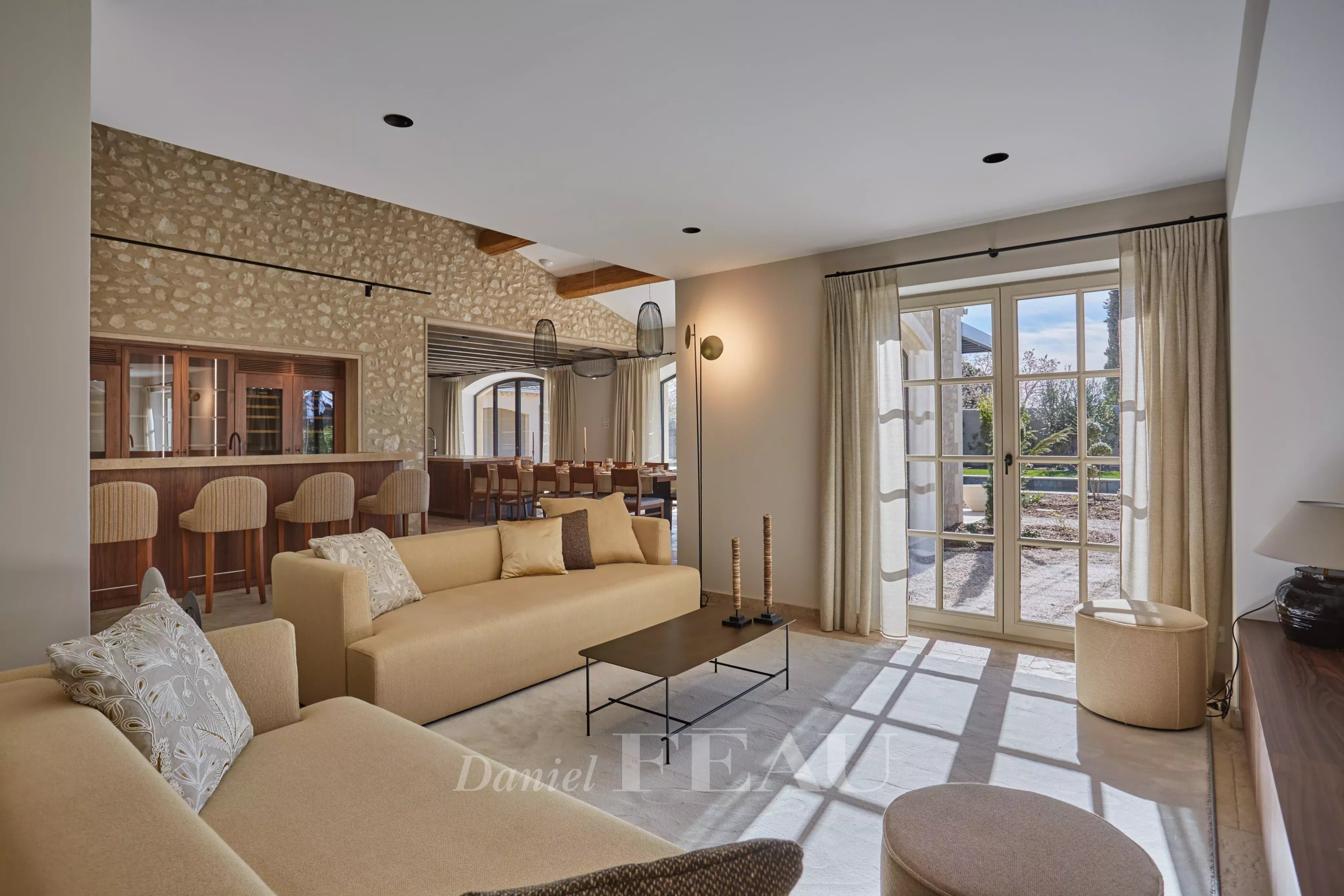 Interior of a renovated stone house with a bright and modern living room in Maussane-les-Alpilles.
