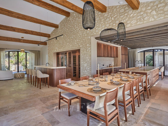 Interior of a renovated stone house in Maussane-les-Alpilles, with a large dining table and exposed beams.