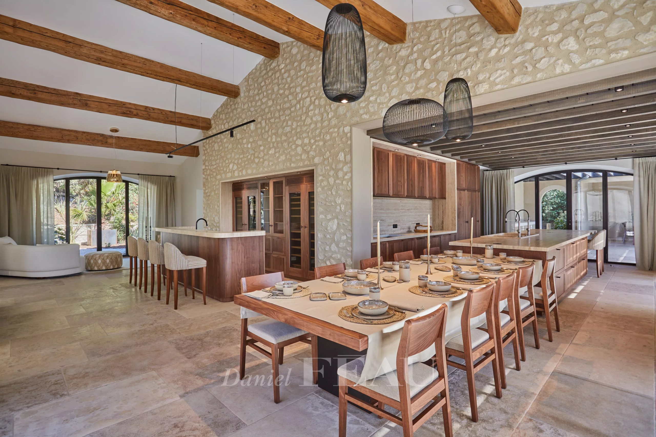 Interior of a renovated stone house in Maussane-les-Alpilles, with a large dining table and exposed beams.