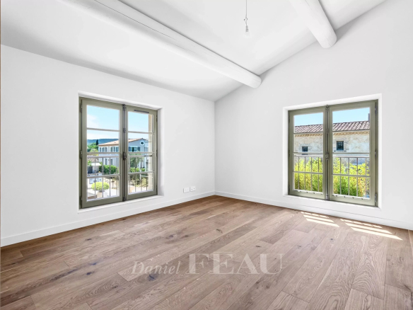 Intérieur d'une maison contemporaine à Eygalières avec deux fenêtres et un sol en bois.