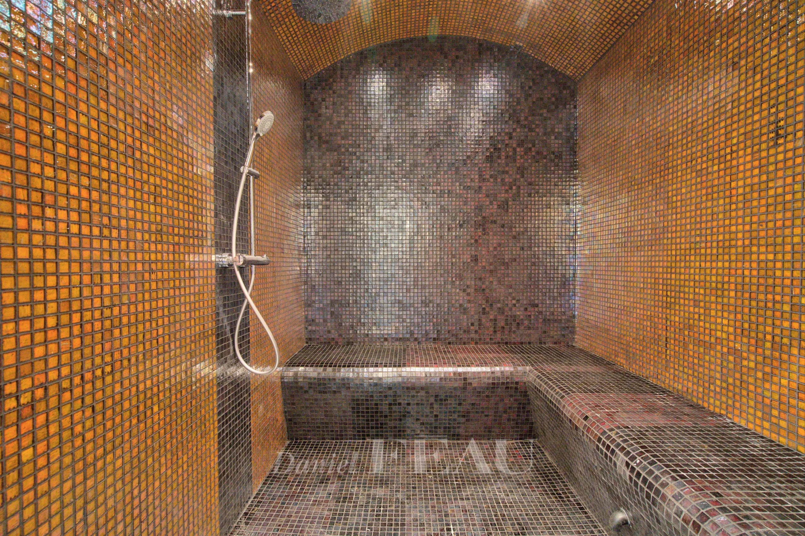 Intérieur d'un hammam avec mosaïque colorée et douche