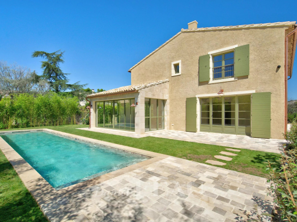 Maison contemporaine avec piscine à Eygalières, jardin paysager et façade en pierre.