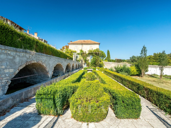 Château du XVIIème siècle à Valensole avec jardins et arches en pierre.