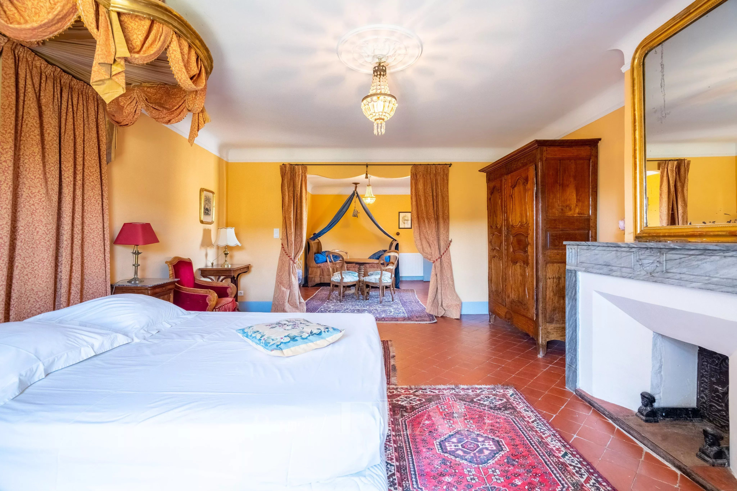 Chambre d’un château à Valensole Intérieur d'une chambre spacieuse avec lit, fauteuils et cheminée dans un château du XVIIème siècle à Valensole.