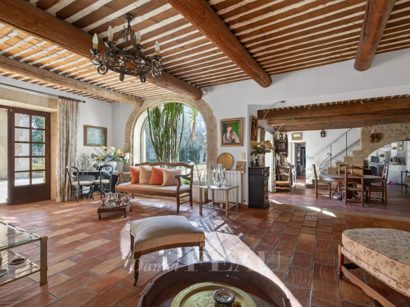 Interior of a Provençal farmhouse with exposed beams and traditional furniture.