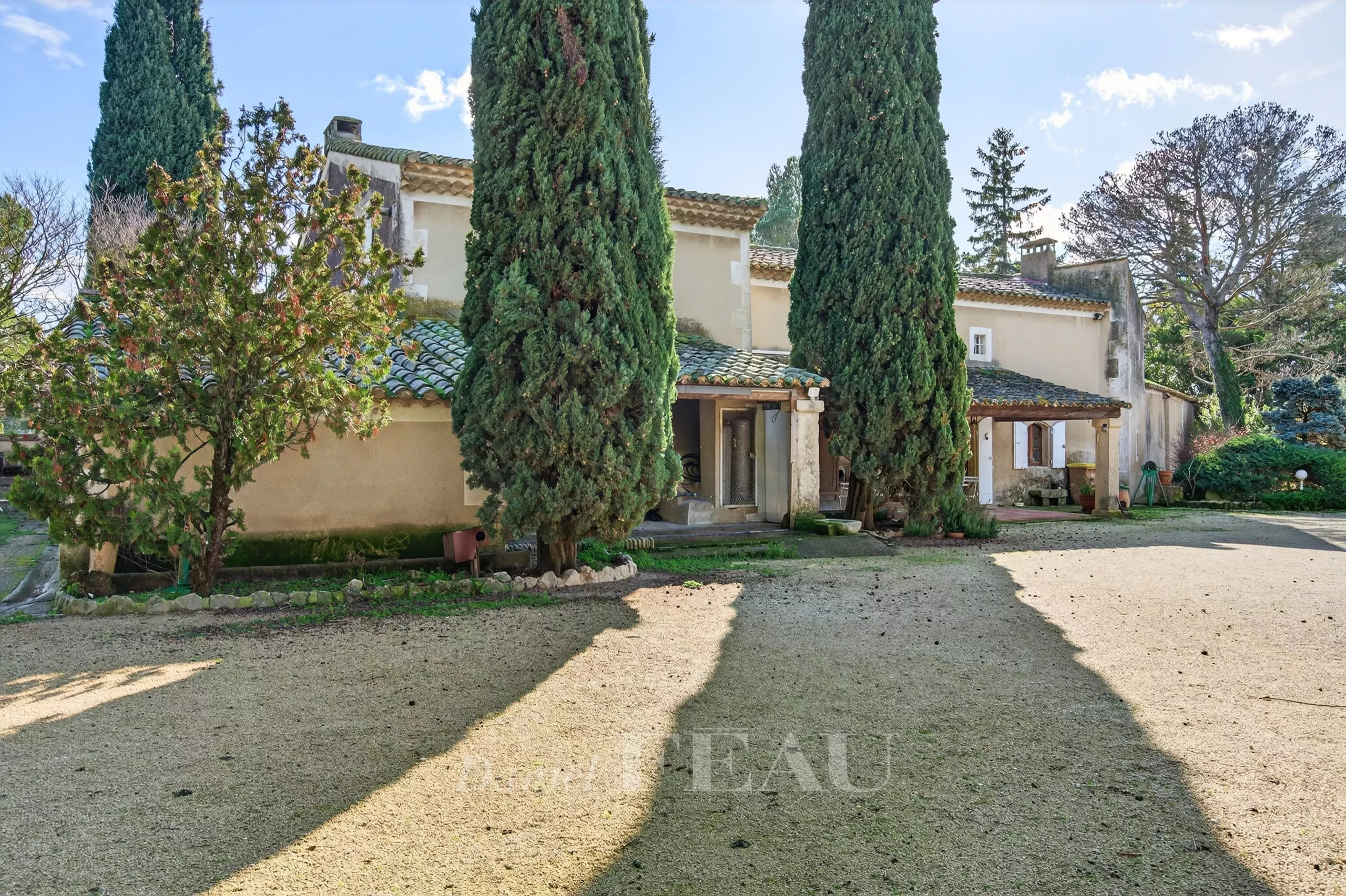 Provençal farmhouse restored in 1985, located in Cavaillon, surrounded by cypress trees and a wooded park.