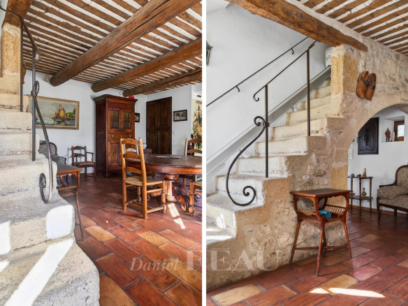 Interior of a Provençal farmhouse with stone staircase and traditional furniture.