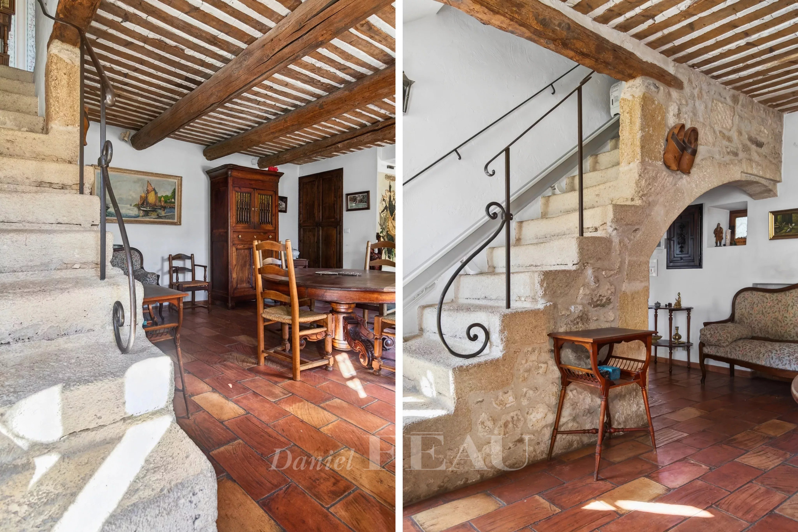 Interior of a Provençal farmhouse with stone staircase and traditional furniture.