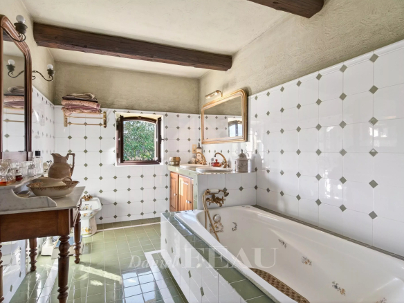 Bathroom of a Provençal farmhouse with bathtub and green tiles in Cavaillon.