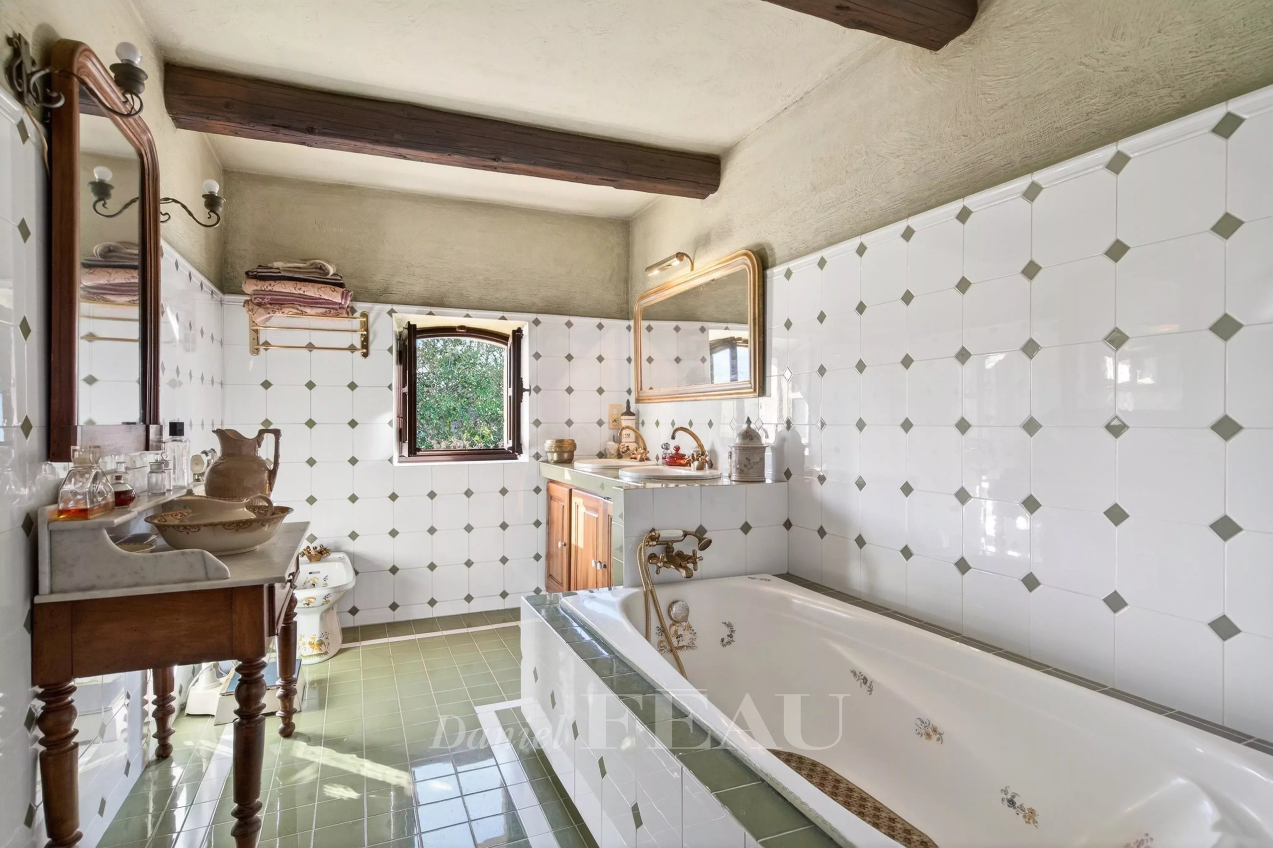 Bathroom of a Provençal farmhouse with bathtub and green tiles in Cavaillon.