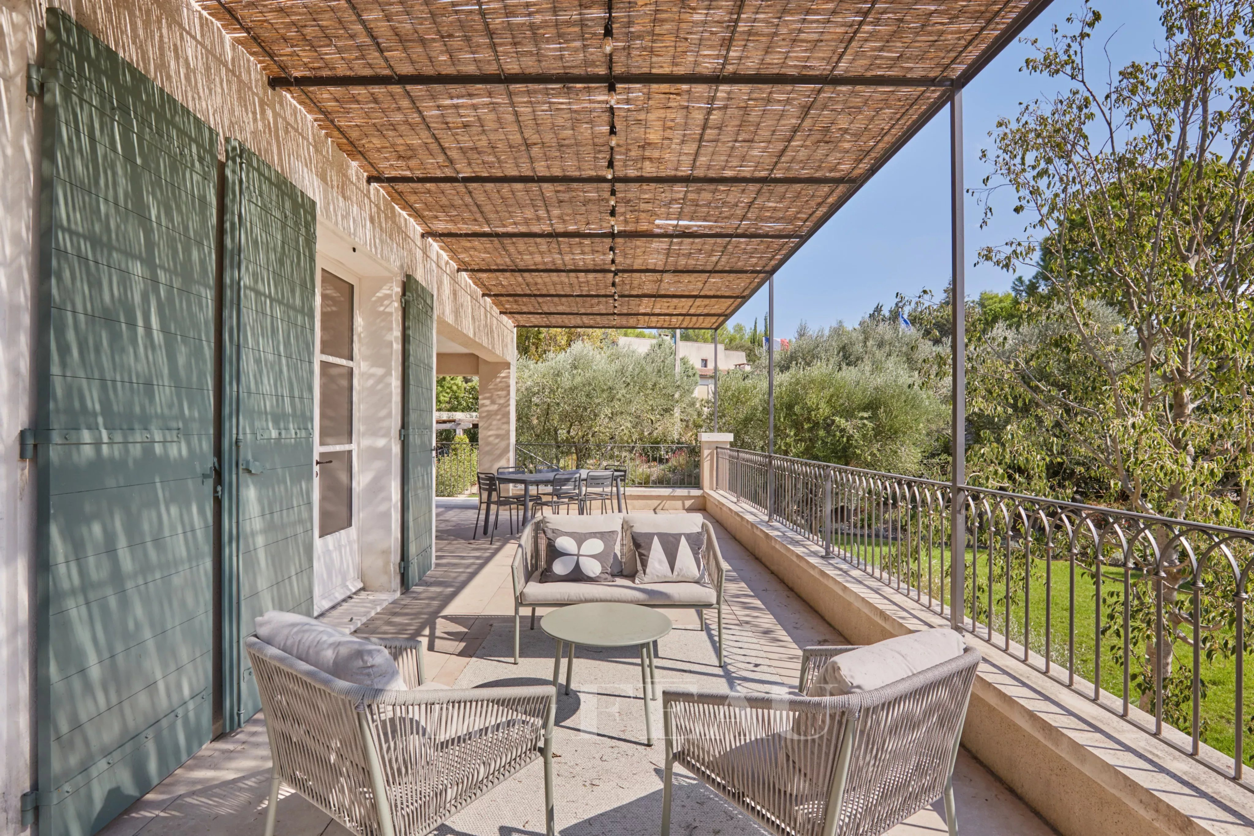 Terrace of a renovated house in Paradou Terrace of a renovated house with outdoor furniture, overlooking a Mediterranean garden.