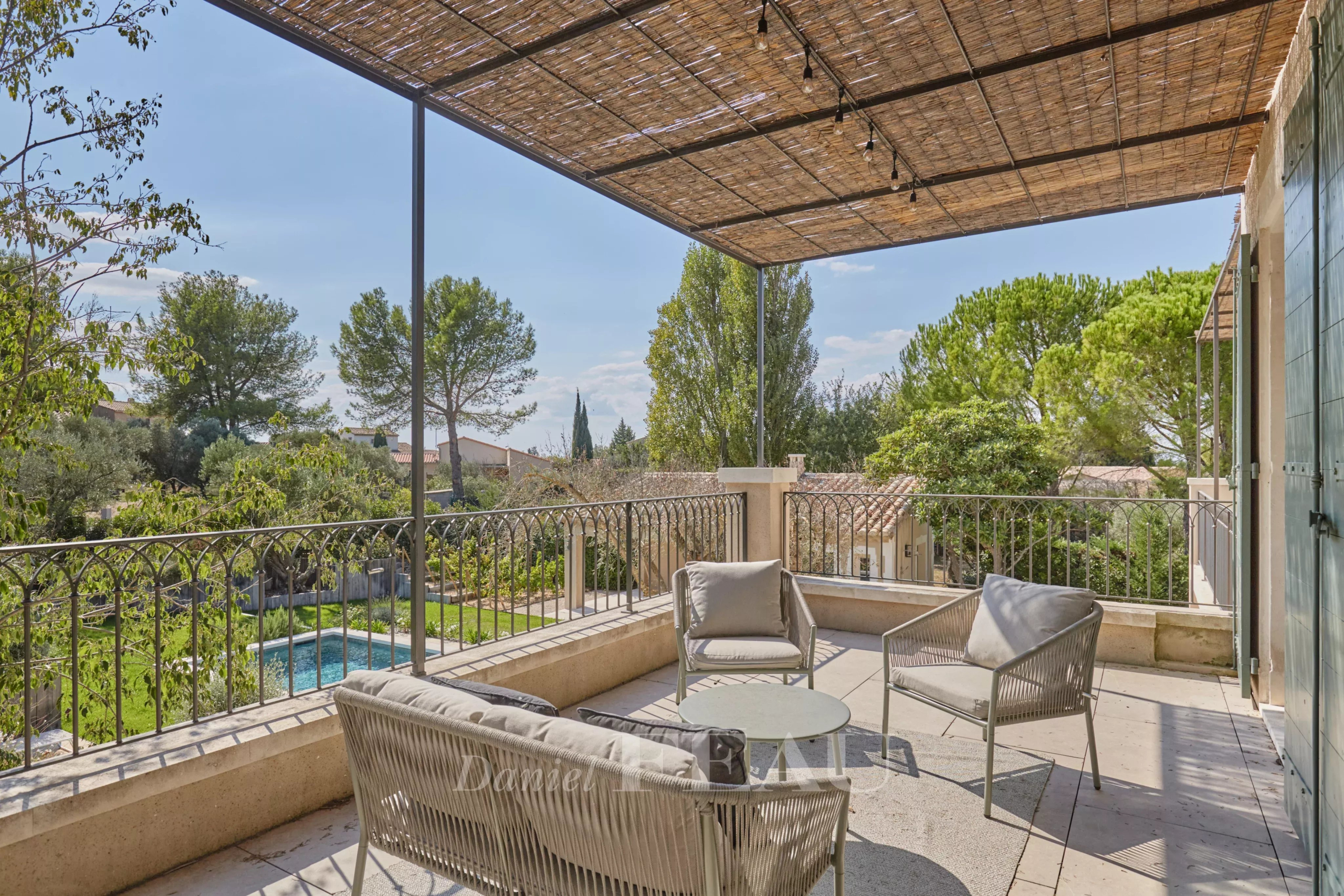 Terrace of a renovated house in Paradou Terrace of a renovated house with outdoor furniture, overlooking a Mediterranean garden.