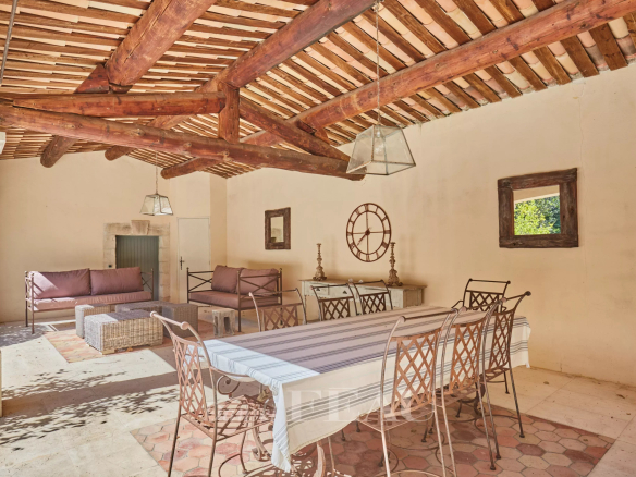 Terrasse couverte d'une maison d'architecte à Saint-Rémy-de-Provence avec mobilier en fer forgé.