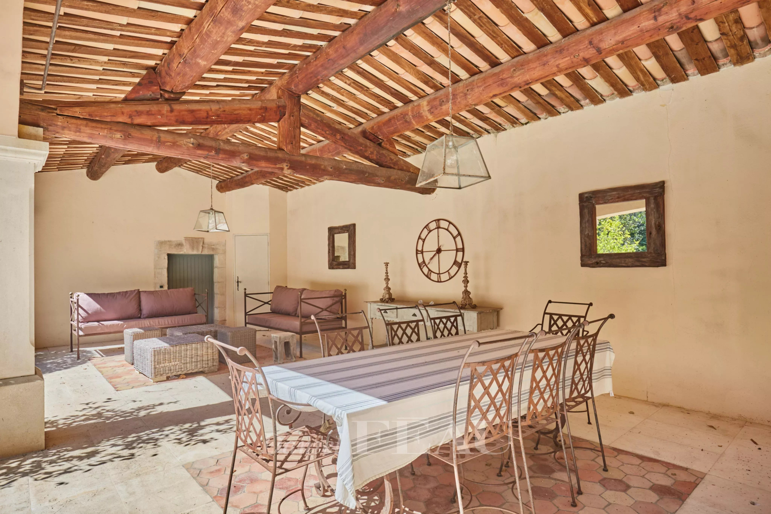 Terrasse couverte d'une maison d'architecte à Saint-Rémy-de-Provence avec mobilier en fer forgé.