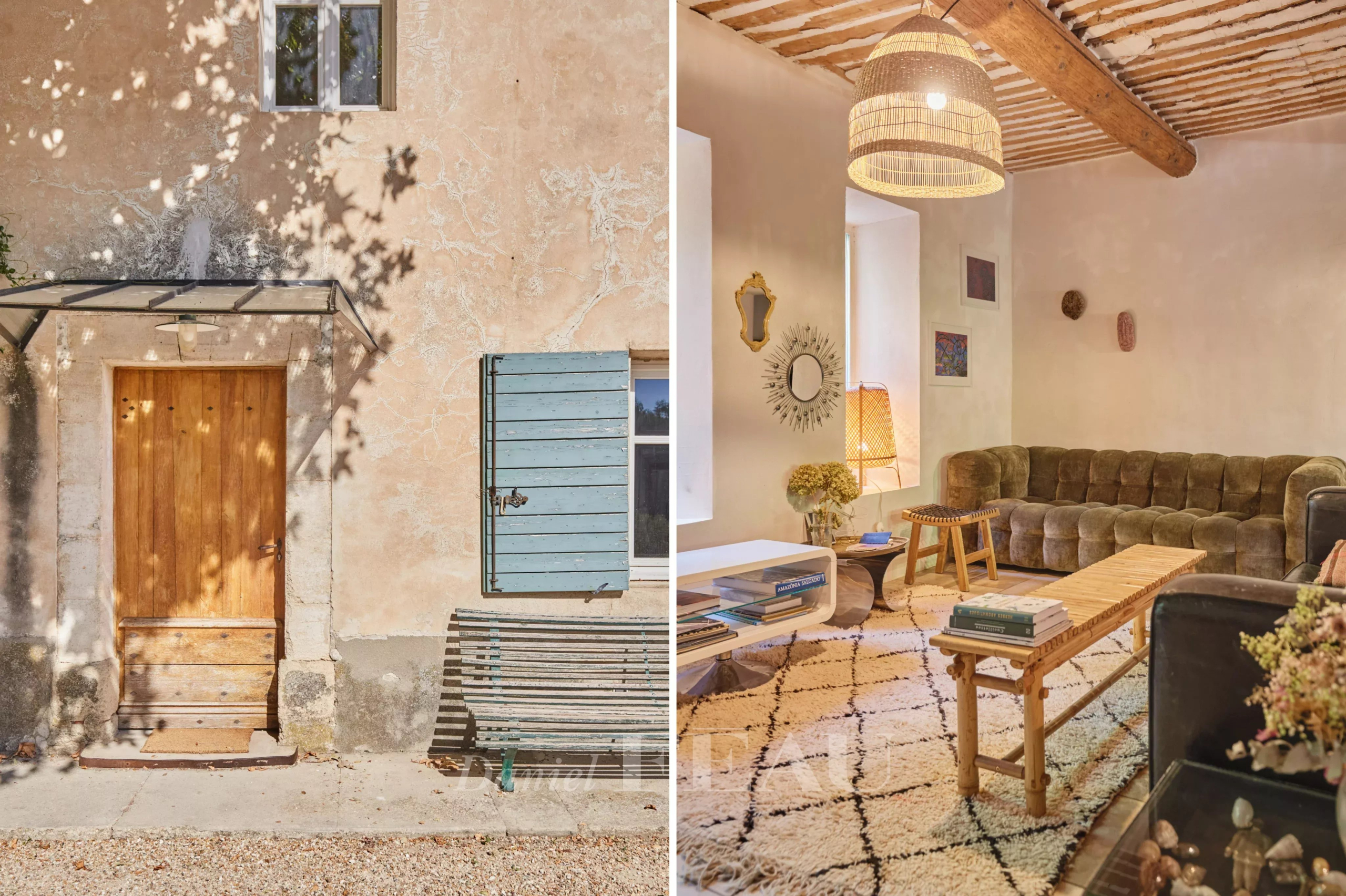Entrée d'une ferme provençale avec porte en bois et volets bleus, et un intérieur chaleureux avec canapé et table en bois.