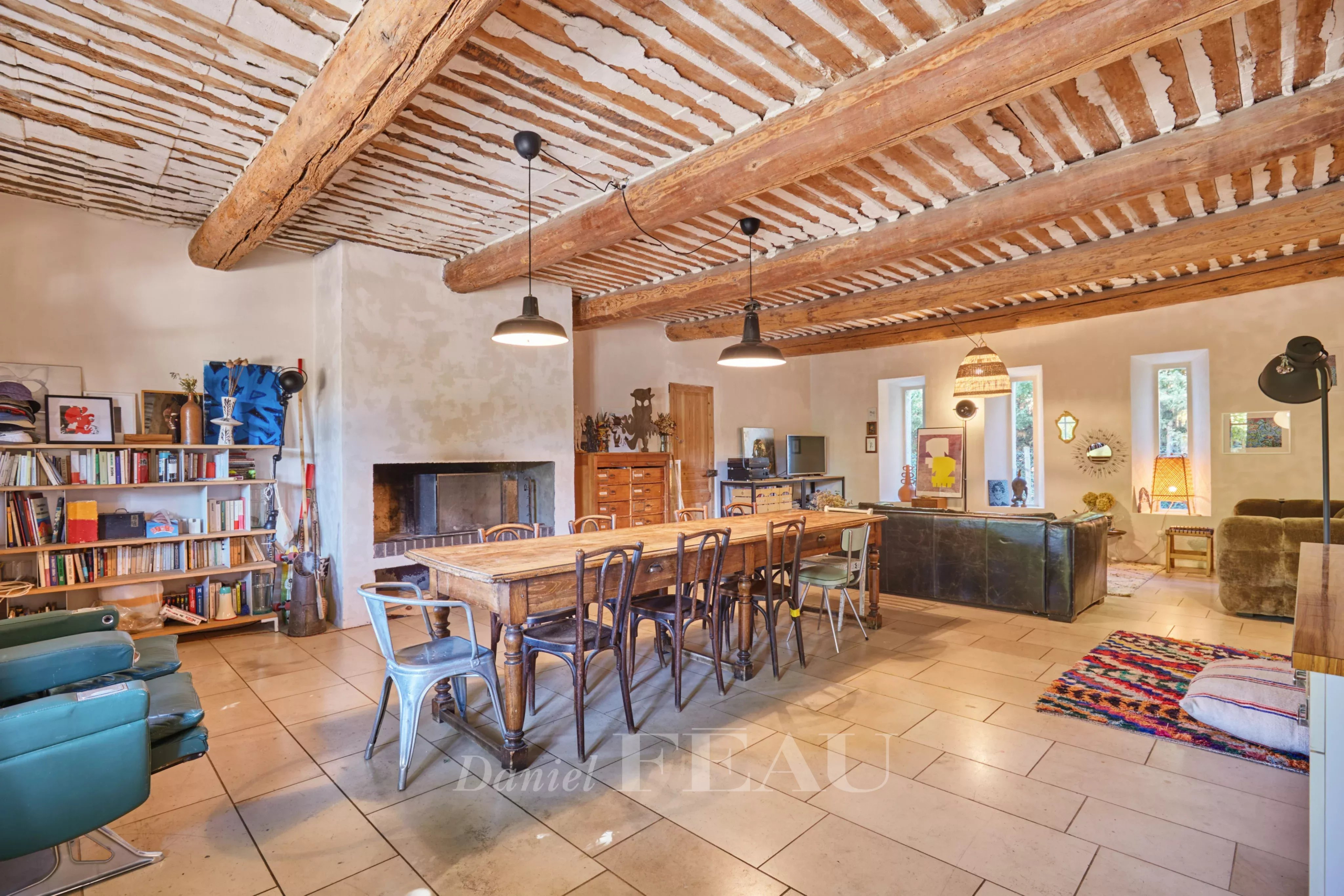 Intérieur d'un mas provençal avec poutres apparentes et mobilier convivial.