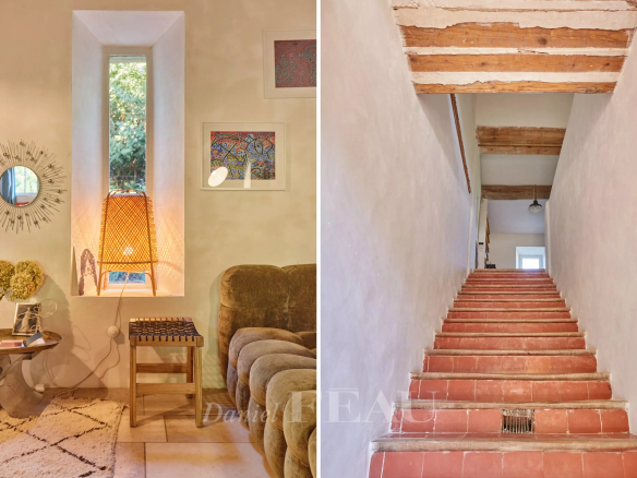 Intérieur d'un mas provençal avec un coin salon et un escalier en terre cuite.
