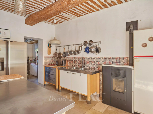 Cuisine d'un mas provençal avec poutres apparentes et carrelage, Cavaillon.