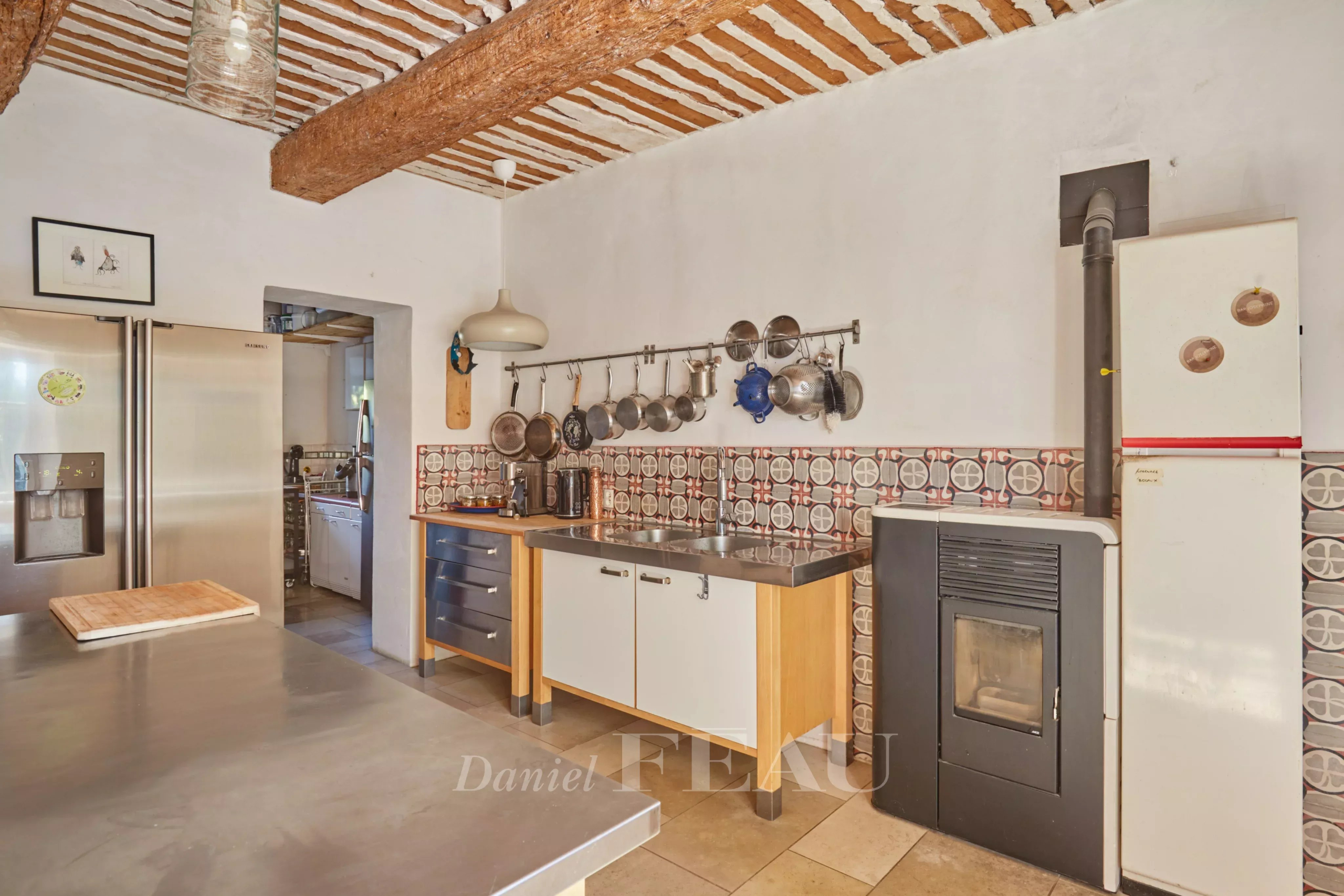 Cuisine d'un mas provençal avec poutres apparentes et carrelage, Cavaillon.
