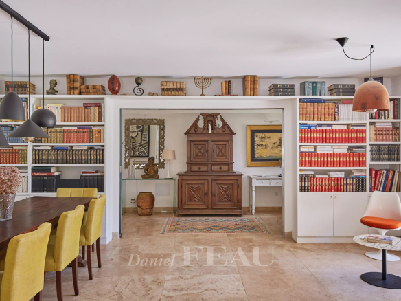 Intérieur d'une maison à Eygalières avec une salle à manger et des étagères remplies de livres.