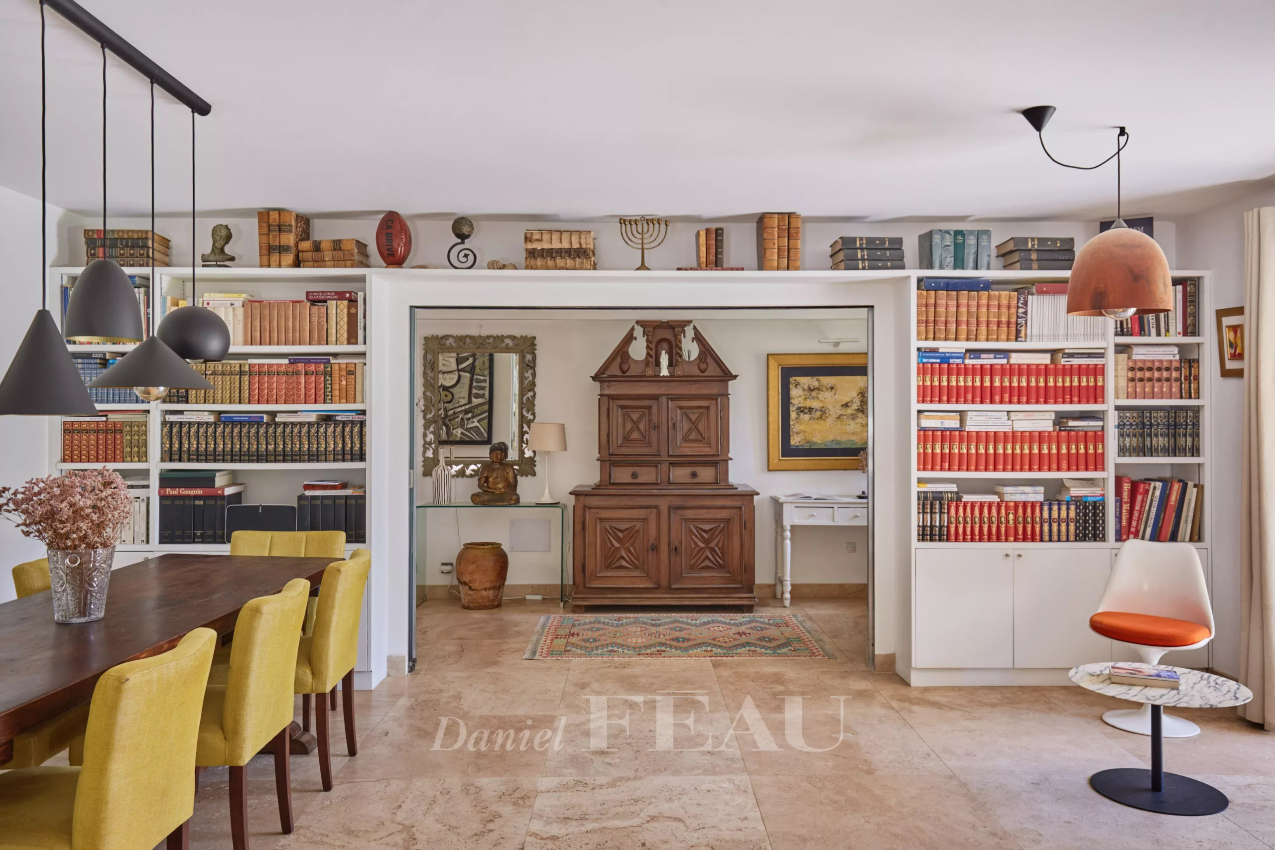 Intérieur d’une maison à Eygalières Intérieur d'une maison à Eygalières avec une salle à manger et des étagères remplies de livres.