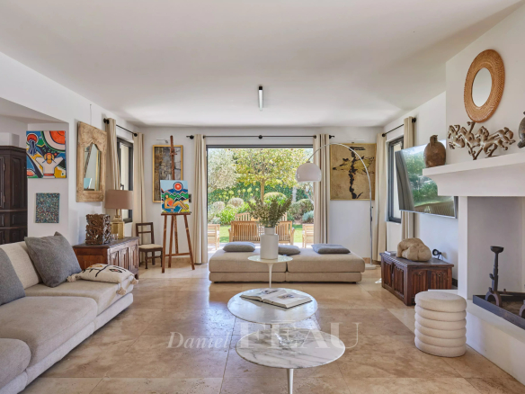 Intérieur d'une maison à Eygalières avec un salon lumineux et des œuvres d'art aux murs.