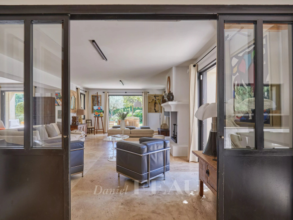Intérieur d'une maison à Eygalières avec salon lumineux et accès au jardin.
