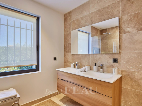 Salle de bain moderne avec meuble en bois, miroir et douche, lumière naturelle à Eygalières.