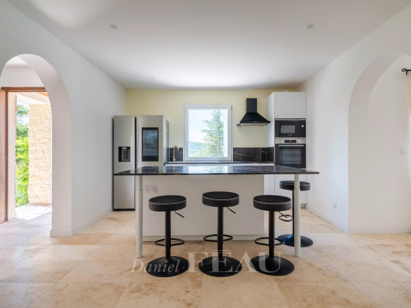 Cuisine moderne et lumineuse d'une villa à Rustrel, avec comptoir et appareils électroménagers.
