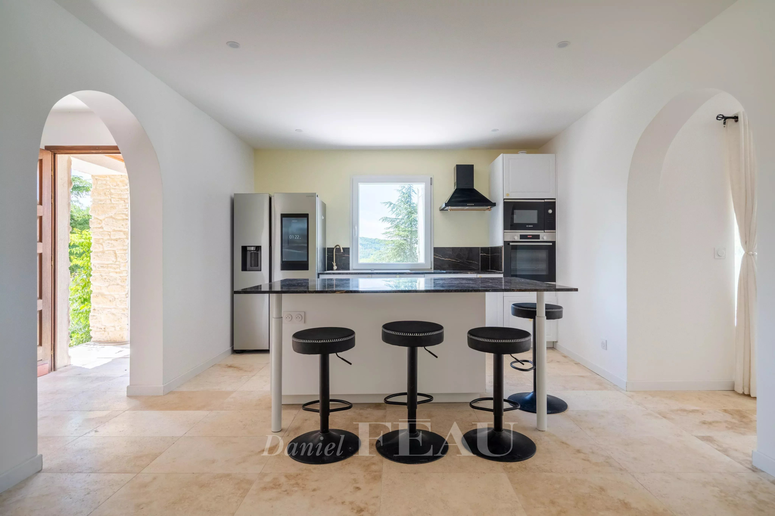 Cuisine moderne et lumineuse d'une villa à Rustrel, avec comptoir et appareils électroménagers.