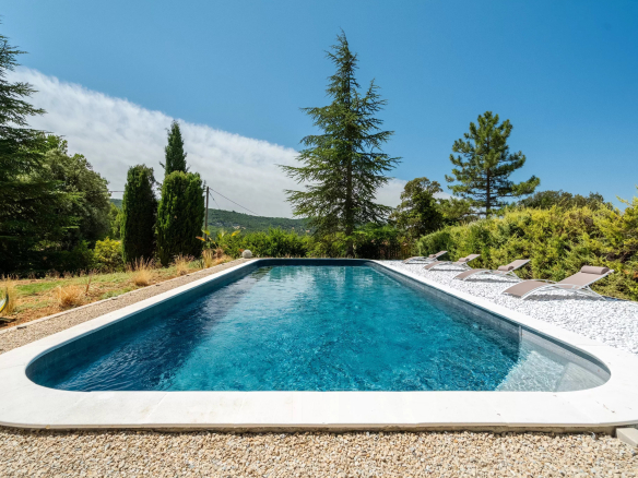 Piscine d'une villa à Rustrel avec vue sur le paysage environnant.