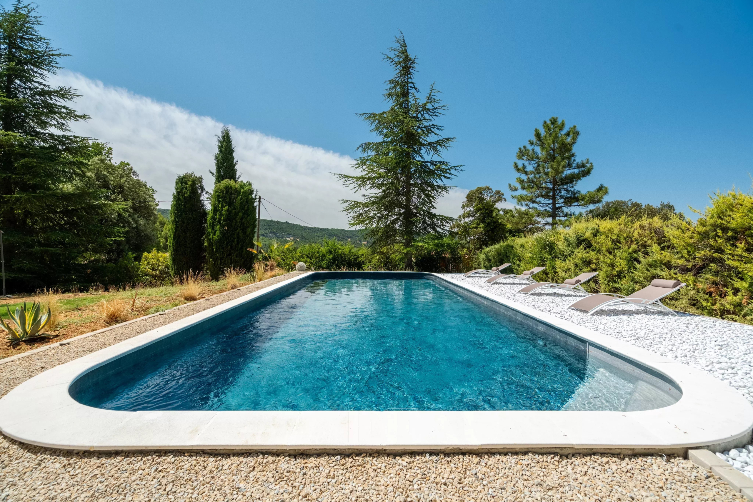 Piscine d'une villa à Rustrel avec vue sur le paysage environnant.