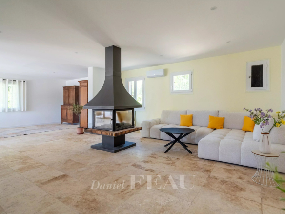 Intérieur d'une villa à Rustrel avec un salon lumineux et une cheminée moderne.
