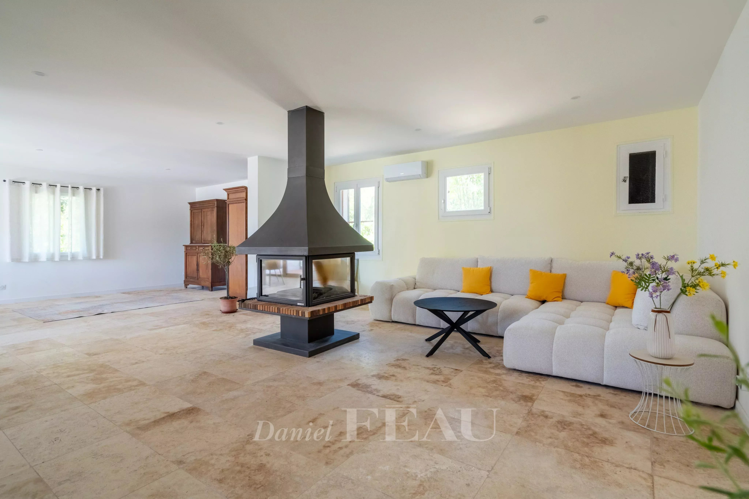 Intérieur d'une villa à Rustrel avec un salon lumineux et une cheminée moderne.