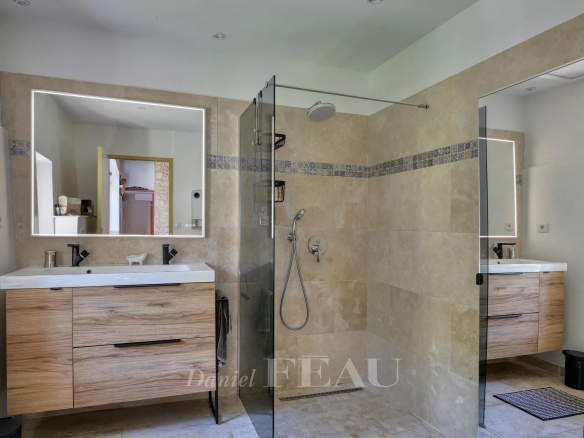 Salle de bain moderne avec douche et meuble en bois, rénovée dans un mas du XVIIIème siècle à Avignon.