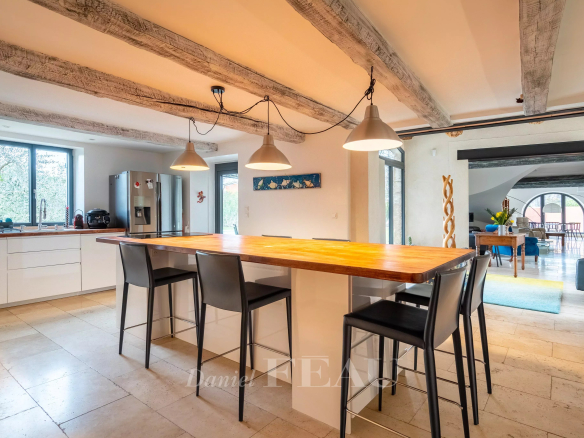 Intérieur d'un mas du XVIIIème siècle rénové, avec une cuisine moderne et un bar en bois.