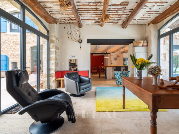 Intérieur d'un mas rénové du XVIIIème siècle à Avignon, avec mobilier moderne et murs en pierre apparente.