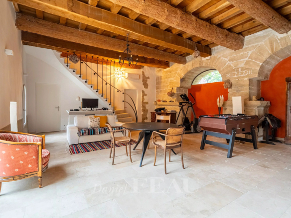 Intérieur d'un mas du XVIIIème siècle rénové à Avignon, avec salon, salle à manger et éléments en bois.