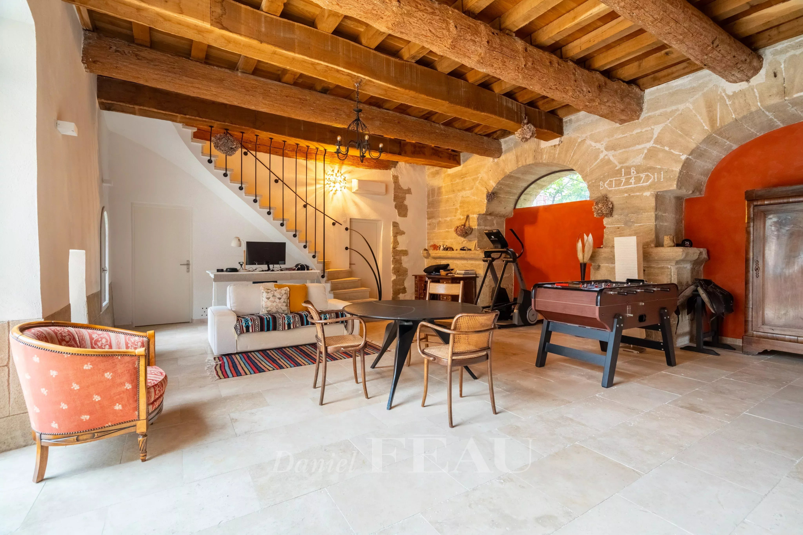 Intérieur d'un mas du XVIIIème siècle rénové à Avignon, avec salon, salle à manger et éléments en bois.