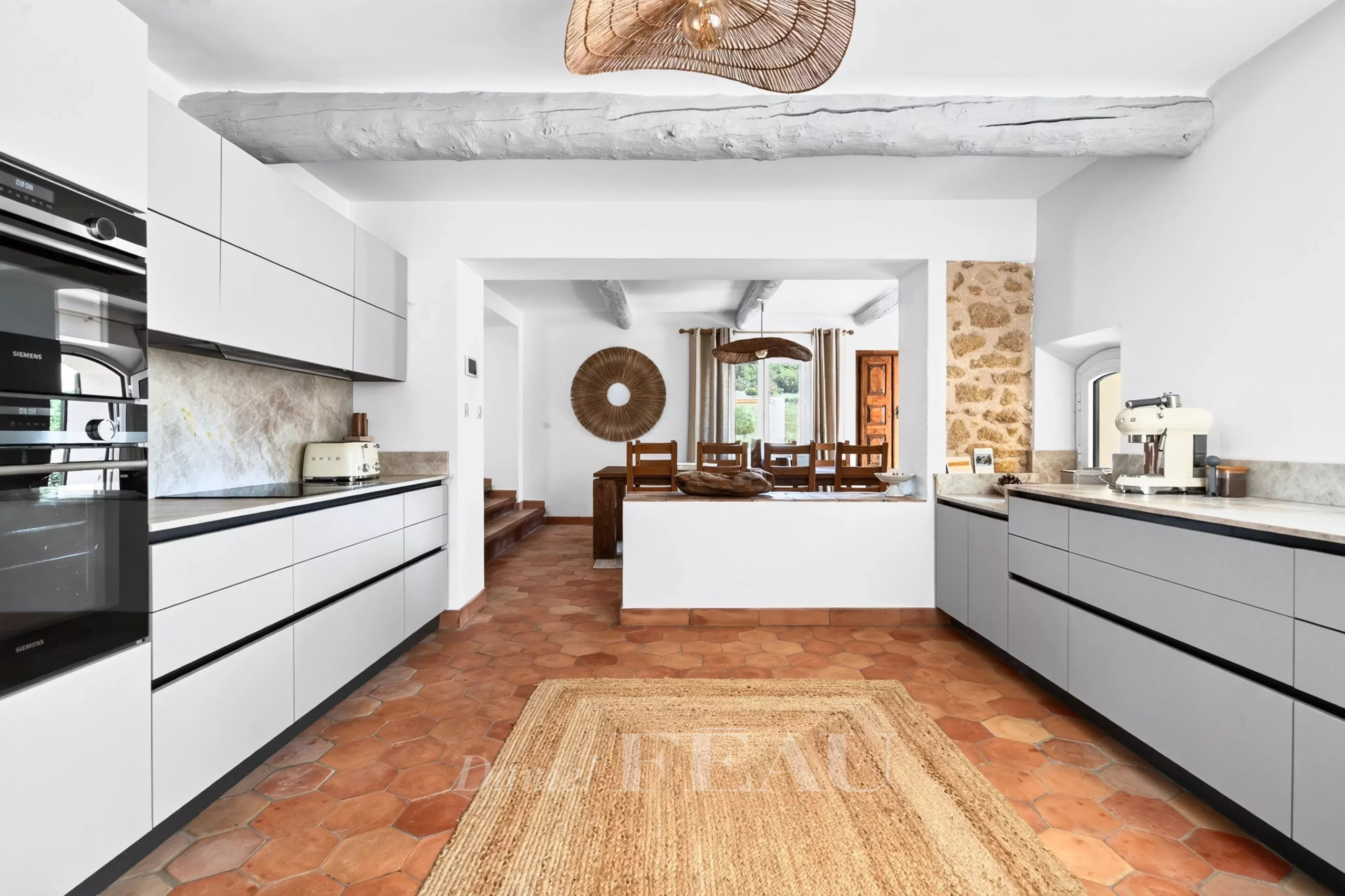Cuisine rénovée de la propriété à Lourmarin Cuisine moderne avec carrelage en terre cuite et éléments en bois.